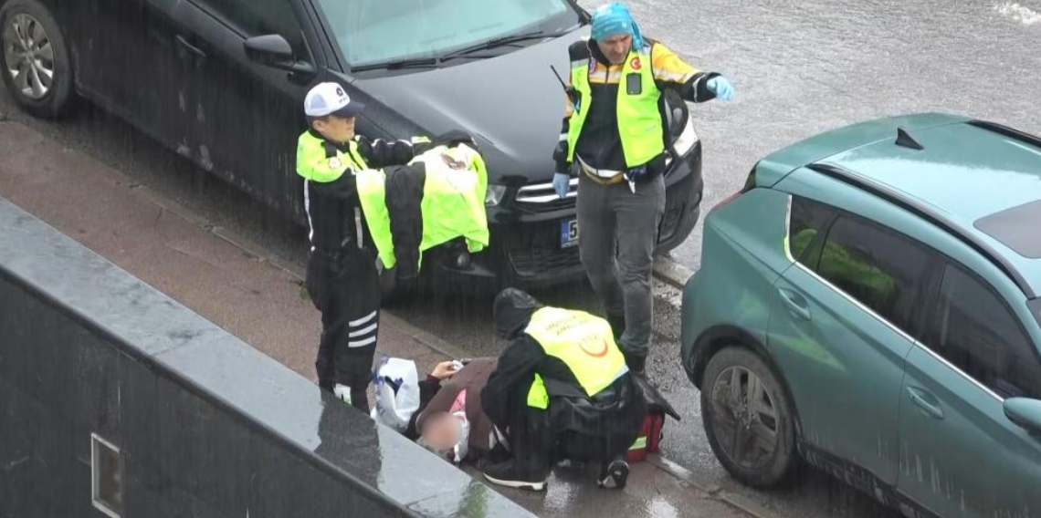 Polisin yaralı kadına yardımı yürekleri ısıttı: Kaldırıma taşıdı, ıslanmasın diye yelekle korudu